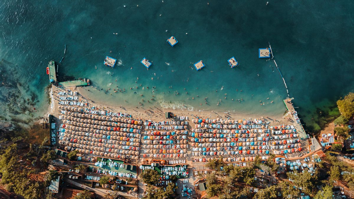 A Turkish resort beach crowded with sunbeds and umbrellas at the height of summer